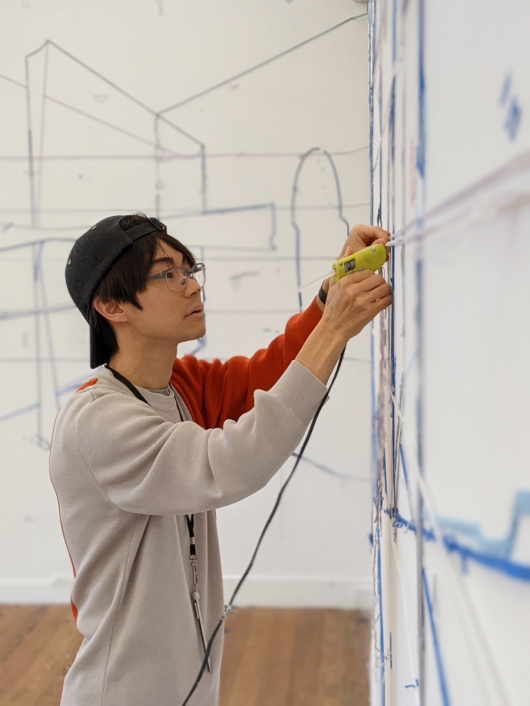  Keita Mori en pleine création d'une oeuvre éphémère dans les espaces d'exposition du Centre d'art comtemporain de Pontmain - Résidences 2021.